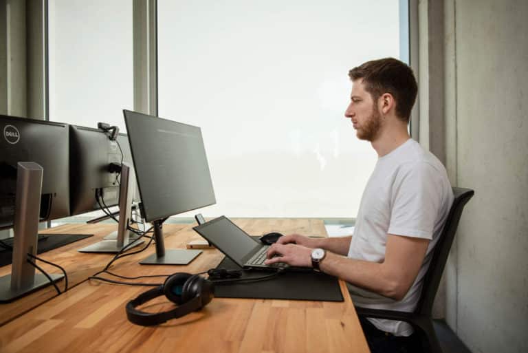 WordPress-Entwickler Joscha Holzhäuer sitzt am Schreibtisch und programmiert eine Custom WordPress-Website