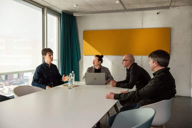 Moritz Bappert und Lennart Schleifer besprechen mit Kunden im Konferenzraum das neue WordPress-Webdesign